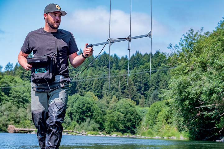Natural Resources graduate student James Whelan uses a hand-held antenna to mobility track and locate signals from radio tags implanted
on fish.