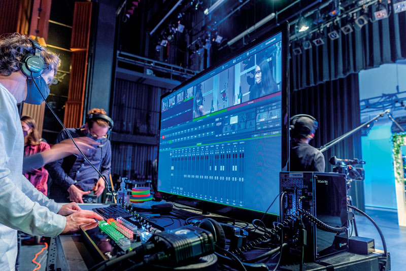 students at a computer with video editing software on the screen