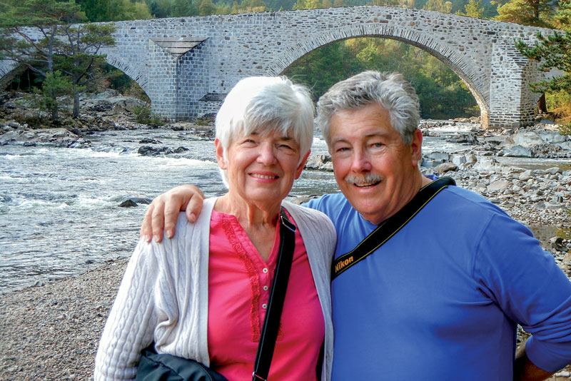 Jack and Diana posing together under a bridge next to a river
